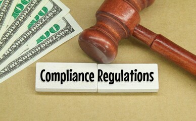 banknotes, hammers and wooden boards with the words COMPLIANCE REGULATIONS