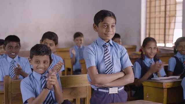 All students clapping for intelligent or brilliant kid at classroom for achievement - concept of encouragement, proud, motivational and inspiration