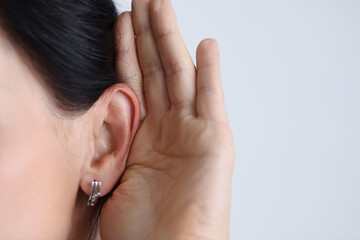 Woman held hand to ear and listened attentively.