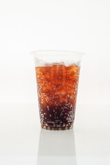 Soft drink in a plastic glass on a white background.