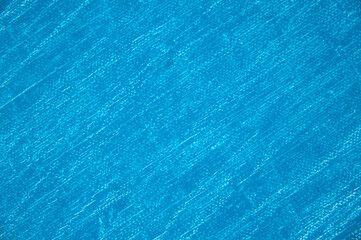 white artistic canvas of rough weave covered with a thin layer of blue primer close-up, tinting, free space