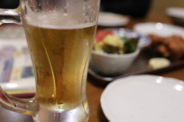 ビールのグラスと料理が並ぶ飲み会のテーブル