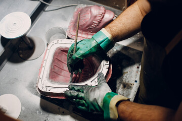 Artisan craftsman create mask based on plaster cast. Gypsum mold and plastic mask sculpting.
