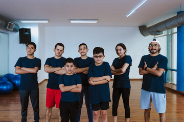 Fototapeta premium Latin teenagers and hispanic children with instructor man posing together in work out sport class in Mexico Latin America