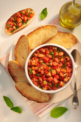 Classic bruschetta – healthy vegetarian Italian snack in a morning or evening light on a gray table. Top view vertical photo.