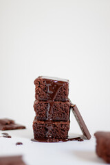 a stack of chocolate brownies on top with chocolate sauce.