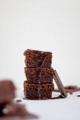 a stack of chocolate brownies on top with chocolate sauce.