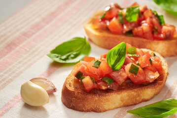 Classic bruschetta – healthy vegetarian Italian snack in a morning or evening light on a gray table. Photo with place for your text. Shallow depth of field.