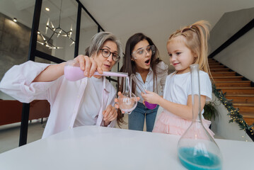 Family doing chemical experiment, mixing flasks indoors