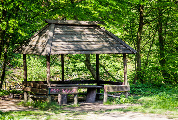 a rough wooden gazebo in the forest