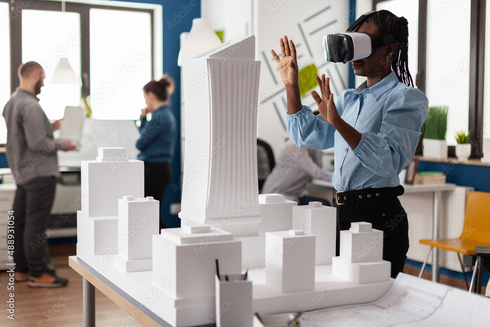 Poster architect using vr headest to look at white foam scale model of real estate project. engineer workin