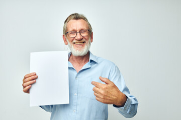 Photo of retired old man holding a sheet of paper copy-space posing isolated background