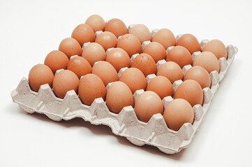 Thirty eggs in a paper tray on a white background