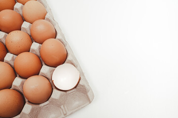 White background with copy space, Eggs in a paper tray and broken eggshells.