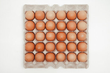 Thirty eggs in a paper tray on a white background