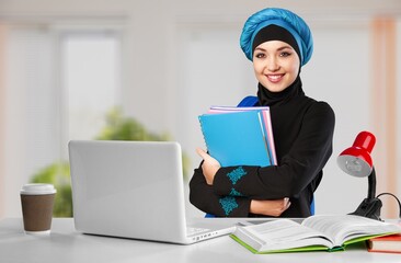Arab at work. Emirati woman using computer tablet typing. Girl in Abaya and Hijab