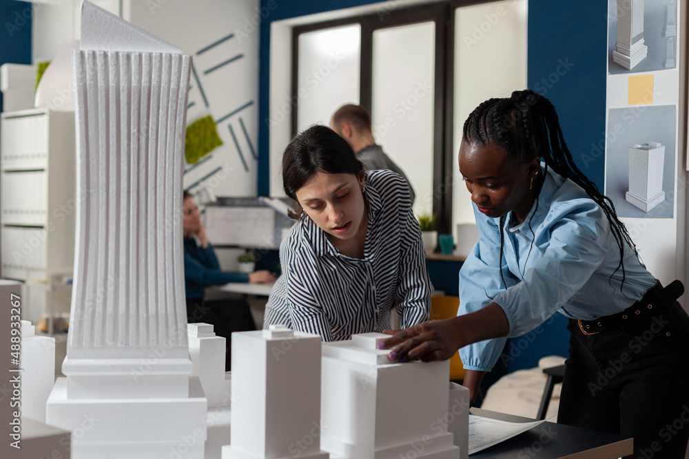 Aufkleber architectural engineers doing teamwork reading construction plans over table with white foam scale m