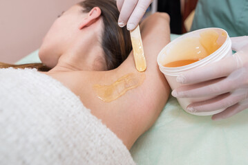 Obraz na płótnie Canvas Cosmetology sugar hair removal of a female armpit in a spa center