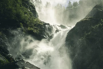 Fotobehang Een stromende waterval in Noorwegen © Montanarealthy/Wirestock