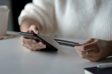 Female hands holding credit card and using smartphone. Online shopping