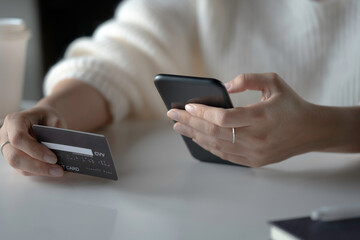 Female hands holding credit card and using smartphone. Online shopping