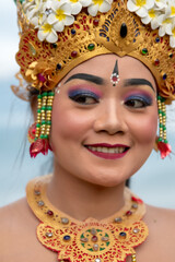Portrait of beautiful young balinese woman dancer wearing a traditional costume in mountain temple.