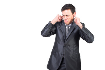 Annoyed businessman in suit covering ears with fingers