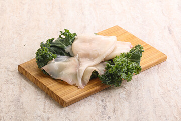 Raw squid over wooden board