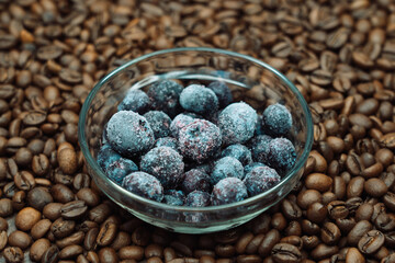 blueberries in a glass dish on roasted coffee beans