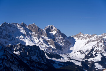 Fototapeta na wymiar Aerial view of mountain panorama at the Swiss Alps seen from ski resort Engelberg, focus on background. Photo taken February 9th, 2022, Engelberg, Switzerland.
