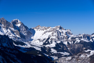Fototapeta na wymiar Aerial view of mountain panorama at the Swiss Alps seen from ski resort Engelberg, focus on background. Photo taken February 9th, 2022, Engelberg, Switzerland.