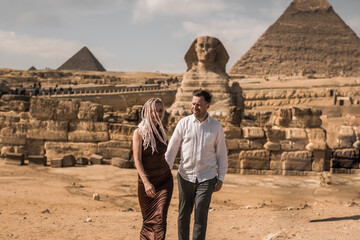 Happy couple and Pyramid, Cairo, Egypt. Tourists having fun in Giza