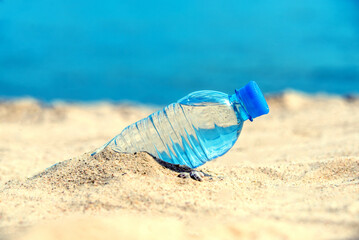 Fototapeta na wymiar A bottle of drinking water on the sea beach 
