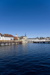 Obraz premium Medieval old town of Luzern with famous covered wooden Chapel Bridge (German: Kapellbrücke) and stone water tower on a sunny winter day. Photo taken February 9th, 2022, Lucerne, Switzerland.