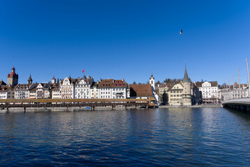 Medieval old town of Luzern with famous covered wooden Chapel Bridge (German: Kapellbrücke) and stone water tower on a sunny winter day. Photo taken February 9th, 2022, Lucerne, Switzerland.