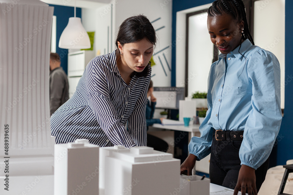Aufkleber architectural engineers working together reading construction plans standing next to table with foam