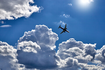 Passenger the plane flying above the white clouds. Passenger transportation by air. Travel by plane.