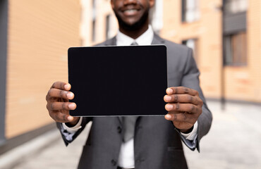 African american businessman demonstrating tablet with blank screen, demonstrating space for your ad, mockup