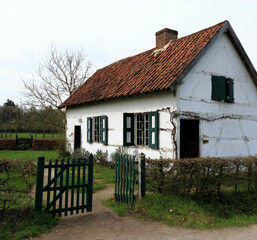 Fototapeta na wymiar green windows on a white farmhouse in a rural landscape, Bokrijk, Belgium