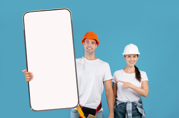 Two Construction Workers In Helmet Holding Showing Big Cellphone Screen