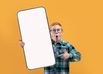 Little school boy showing white empty smartphone screen