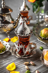 Oriental sweets. Lukum, pistachio baklava. Fragrant tea. Turkish mood still life. For advertising, window dressing, travel posters and cafes.