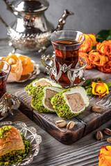 Oriental sweets. Lukum, pistachio baklava. Fragrant tea. Turkish mood still life. For advertising, window dressing, travel posters and cafes.
