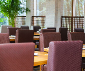 wine red weave texture chairs and wooden tables at empty restaurant cafeteria with wood grid decor