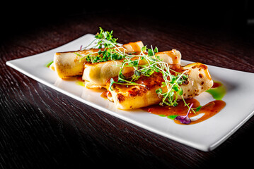 Thin pancakes crepe rolls with ground meat on plate on wooden table dark background