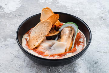 Tomato gazpacho soup with mussels, squid, shrimp in bowl. Seafood, healthy food, close up