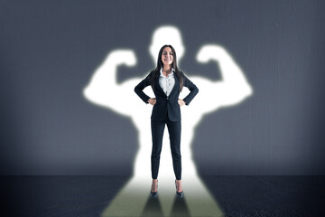 Victory, success and strong woman concept with confident businesswoman on her white shadow with...