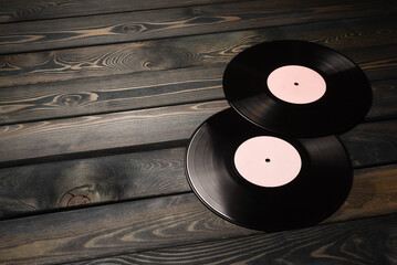 Vinyl records on the old wooden table background with copy space close up.