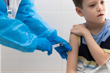 A doctor in a white medical coat and rubber gloves with a phonendoscope makes a coronavirus...