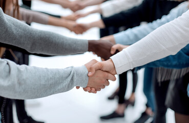 diverse young people shaking hands with each other